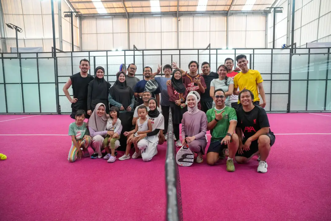 A big group posing on a pink court