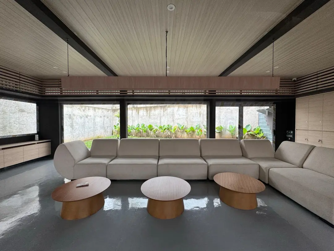 Lounge with a long white sofa and timber tables
